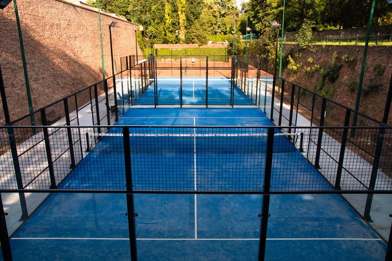 Outdoor paddle tennis court with glass fence