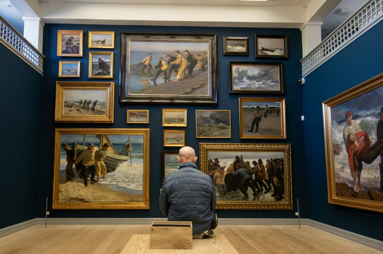 A man viewing oil paintings at an art museum exhibition