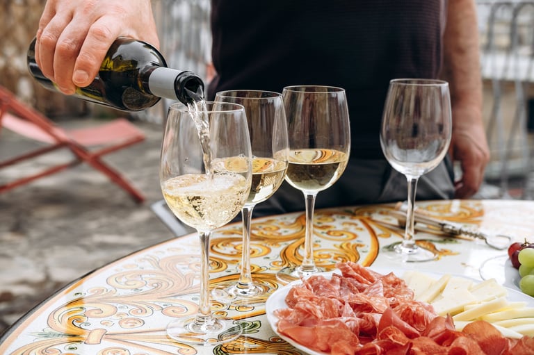 Friends toasting with glasses of white wine at an elegant party