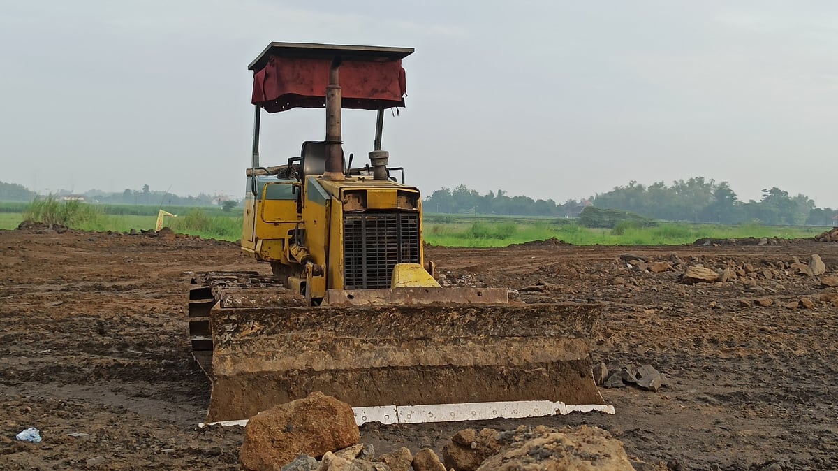 A bulldozer works on land filling and soil compaction to stabilize the ground before construction begins